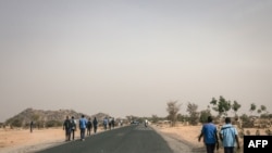 Des lycéens marchent sur la route de Mokolo à Maroua, Région de l'Extrême-Nord, Cameroun, le 20 février 2018.