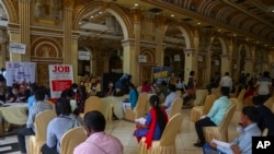 FILE - Applicants seeking employment wait to attend interviews during a job fair in Hyderabad, India, July 24, 2021.