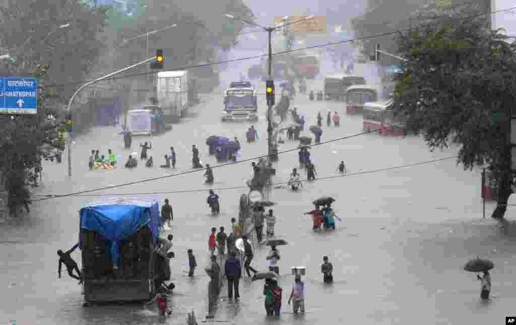 People walk through a flooded street following heavy monsoon rains in Mumbai, India.