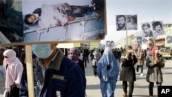 Protesters carry portraits of Afghans who were killed in the past three decades of war and violence during a demonstration for human rights, Kabul, Dec. 10, 2012.