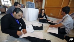 Workers in the independent commission tabulate votes in Tunisia after the country's general elections at a counting center in Tunis, Tunisia, October 24, 2011.