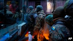 Volunteers from the Azov battalion get on a bus in Kyiv bound for the eastern part of Ukraine to join the fighting against pro-Russian separatists, Jan. 17, 2015.