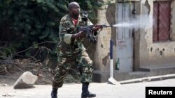 Seorang tentara Burundi dengan senjata AK-47 menembak ke arah demonstran dalam protes menentang Presiden Pierre Nkurunziza di Bujumbura, Burundi (25/5).