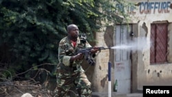 Un soldat armé d'un AK-47 tire sur les manifestants opposés à un trosième mandat du président Pierre Nkurunziza à Bujumbura, Burundi, lundi 25 mai 2015