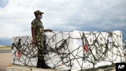FILE - A Malawian policeman guards AstraZeneca COVID-19 vaccines after the shipment arrived at the Kamuzu International Airport in Lilongwe, March 5, 2021.