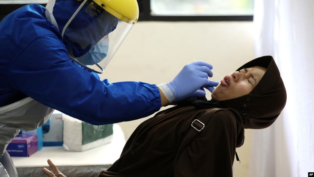 Una mujer reacciona con rechazo a una prueba nasal para el coronavirus en Indonesia, el 21 de junio de 2020.