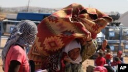 Syrian refugees from Kobani arrive at the Turkey-Syria border crossing of Yumurtalik near Suruc, Turkey, Oct. 1, 2014.