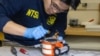 An NTSB investigator inspects a black box from American Airlines flight 5342, Jan. 31, 2025. (National Transportation Safety Board via AFP) 