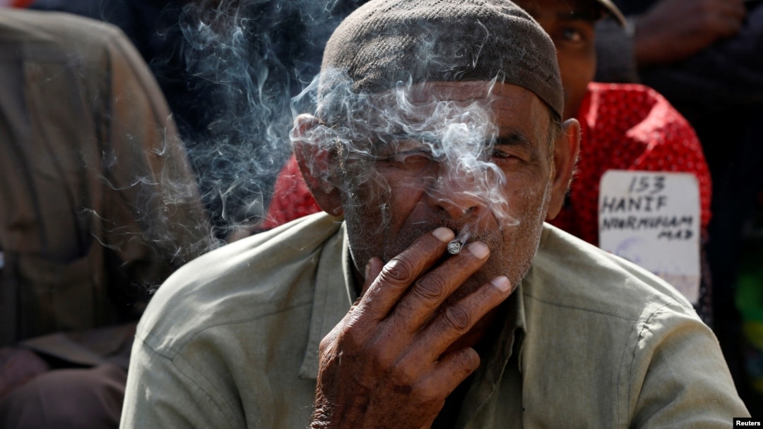 Hussain Jamal, seorang nelayan asal India, merokok bersama lainnya, setelah mereka dilepaskan dari penjara di Karachi, Pakistan, 25 Desember 2016 (foto: REUTERS/Akhtar Soomro)