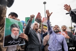 Para demonstran bereaksi dan meneriakkan slogan-slogan saat mereka berkumpul di tengah hujan untuk melakukan protes anti-Israel di Palestine Square, Teheran, pada 28 September 2024. (Foto: AFP)