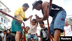 A child survivor of super Typhoon Haiyan is given assistance as he disembarks from a Philippine Navy ship upon arrival at the north harbor in Manila, Nov. 29, 2013. 