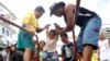 A child survivor of super Typhoon Haiyan is given assistance as he disembarks from a Philippine Navy ship upon arrival at the north harbor in Manila, Nov. 29, 2013. 