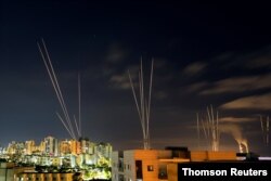 Streaks of light are seen as rockets are launched from the Gaza Strip towards central Israel as seen from Ashkelon, Israel, May 16, 2021.