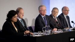 FILE - John Chilcot, center, the chairman of the Iraq Inquiry, sits with committee members Baroness Usha Prashar, left, Roderic Lyne, second from left, Martin Gilbert, second from right, and Lawrence Freedman, right, as he takes questions from journalists, July 30, 2009.