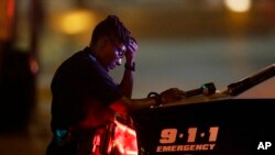 A Dallas police officer, who did not want to be identified, takes a moment as she guards an intersection in the early morning after a shooting in downtown Dallas, July 8, 2016.