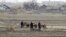 North Korean farmers walk past a field on Hwanggumpyong Island, near the town of Sinuiju, March 2, 2012. 