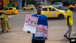 A young man sells calendars featuring Pope Francis outside the Cathedral Notre Dame du Congo in Kinshasa, Democratic Republic of the Congo, Jan. 29, 2023.