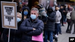 FILE - People wait in line at a COVID-19 testing site in Times Square, New York City, Dec. 13, 2021. Omicron has raced ahead of other variants and is now the dominant version of the coronavirus in the United States.