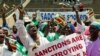 Des manifestants scandent des slogans et agitent le drapeau national du Zimbabwe au cours d'un rassemblement visant à dénoncer les sanctions économiques américaines et européennes, à Harare, le 25 octobre 2019. (AFP)