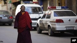 An ethnic Tibetan monk walks past a police station in Danba, Sichuan province. Ethnic tension simmered in remote corners of China's southwestern Sichuan province after security forces fired on demonstrators in a series of deadly clashes that Tibet's gover