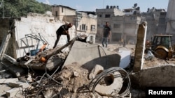 FILE - Palestinians stand at the site of the damaged office of United Nations Relief and Works Agency (UNRWA), following the Israeli raid, in Nour Shams camp, in Tulkarm, in the Israeli-occupied West Bank, Nov. 1, 2024.