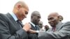 Senegalese President Abdoulaye Wade (R) adjusts a ribbon on his son's jacket, Karim Wade, in 2011. Police in Senegal have said they will question Karim Wade as part of bribery investigations.