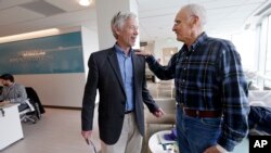 FILE - In this photo taken March 29, 2017, Dr. David Maloney of the Fred Hutchinson Cancer Research Center is greeted by patient Ken Shefveland, whose lymphoma was successfully treated with CAR-T cell therapy. A CAR-T cell treatment developed by Novartis Pharmaceuticals and the University of Pennsylvania has become the first type of gene therapy to hit the U.S. market 