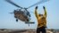 FILE - A sailor directs an MH-60S Sea Hawk helicopter aboard the guided-missile destroyer USS Bainbridge, Aug. 8, 2019, in Persian Gulf waters. 