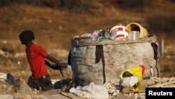 An unemployed man pulls a trolley full of recyclable waste material, which he sells for income, in Daveland near Soweto, South Africa, Aug. 4, 2015.