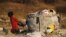 An unemployed man pulls a trolley full of recyclable waste material, which he sells for income, in Daveland near Soweto, South Africa, Aug. 4, 2015.
