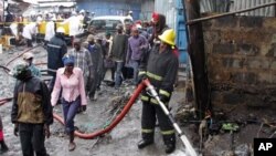 Wakazi wa kitongoji cha Sinai, wakiwatizama wazima moto wakijaribu kuzima moto kufuatia mripuko kwenye bomba la mafuta karibu na Nairobi, Kenya Jumatatu Septemba 12, 2011