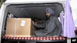 Indian student Nitin Garg's relative Pritam Singh sits in an ambulance besides Garg's body, at the cargo terminal of international airport in New Delhi, India (File Photo)