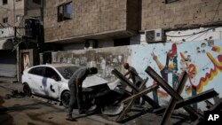 Palestinians inspect the damage after an Israeli military raid in the Jenin refugee camp, West Bank, Sept. 20, 2023. Palestinian health officials say the death toll over a day of fighting between Israel and the Palestinians has risen to six, four from Jenin. 