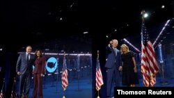 La senadora estadounidense Kamala Harris, a la izquierda, comparte escenario en la Convención Demócrata con el candidato a presidente Joe Biden y su esposa, Jill Biden.
