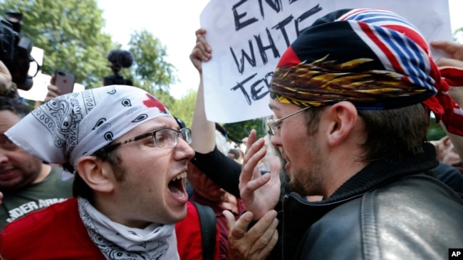 A counterprotester, left, confronts a supporter of President Donald Trump, Aug. 19, 2017, in Boston.