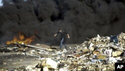 Un manifestante se pone a cubierto durante enfrentamientos con solados israelíes cerca de Ramala, Cisjordania, el 13 de diciembre de 2018.
