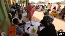 Health workers attend to people during a community COVID-19 coronavirus testing campaign in Abuja, Nigeria, on April 15, 2020.