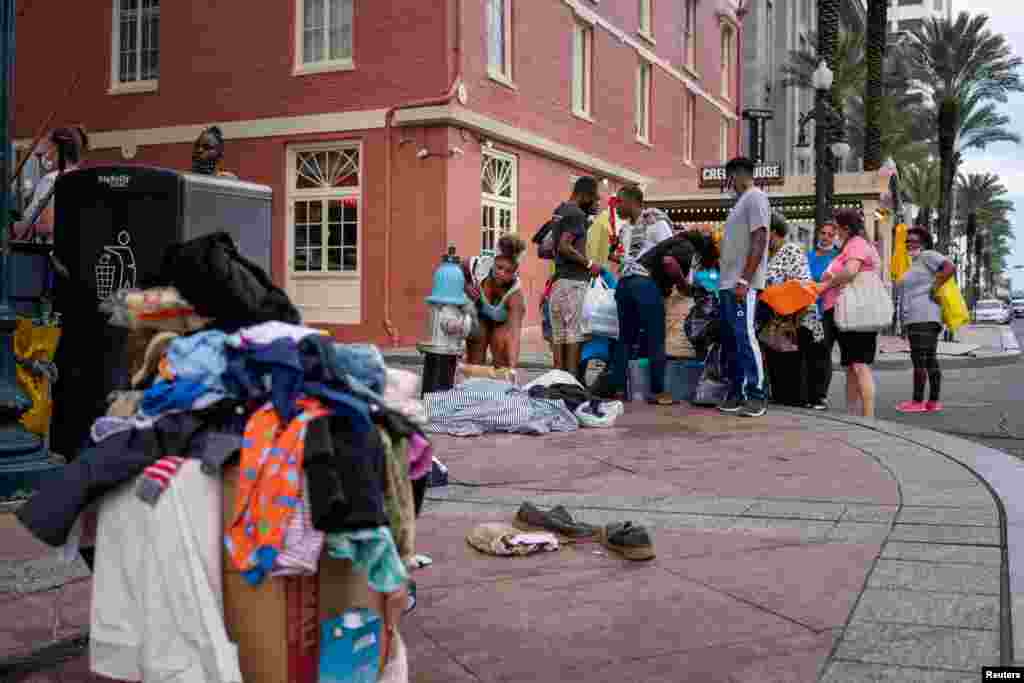 Evacuees displaced by Hurricane Laura look through items that had been dropped off on the curb outside of the New Orleans Marriott in New Orleans, Louisiana, Aug. 30, 2020.