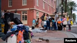 Pengungsi yang mengungsi akibat Badai Laura memeriksa barang-barang yang telah diturunkan di pinggir jalan di luar New Orleans Marriott di New Orleans, Louisiana, AS, 30 Agustus 2020. (Foto: Reuters)