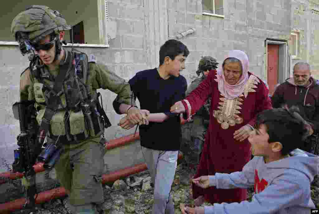 Palestinian women and youths from the village of Kfar Qaddum, near Nablus in the occupied West Bank, scuffle with Israeli soldiers as they try to release a youth from their custody, during clashes following a weekly demonstration against the expropriation of Palestinian lands by Israel.