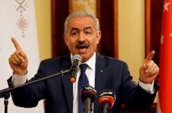 FILE - Palestinian Prime Minister Mohammad Shtayyeh gestures as he speaks during a workshop on cooperation between Palestinians and East Asian countries, in Jericho in the Israeli-occupied West Bank July 3, 2019.