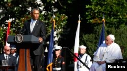 U.S. President Barack Obama, left, speaks as Pope Francis observes during a ceremony held for the pontiff's arrival at the White House in Washington, Sept. 23, 2015. 