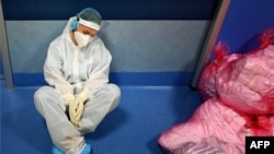 A medical worker in personal protective equipment (PPE) rests at the COVID 3 level Intensive Care Unit (ICU) at the Casal Palocco Hospital, near Rome, Italy.