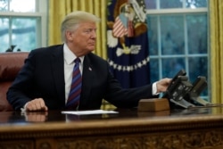 President Donald Trump talks on the phone with Mexican President Enrique Pena Nieto, in the Oval Office of the White House, Aug. 27, 2018.