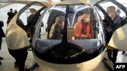 Florian Reuter (kanan), CEO Volocopter GmbH menjelaskan prototip taksi udara "volocopter" kepada dua orang tamunya.