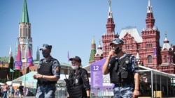 Polisi dan tentara nasional Rusia tampak menggunakan masker saat berjalan di Red Square di pusat kota Moskow pada 18 Juni 2021. (Foto: AFP)