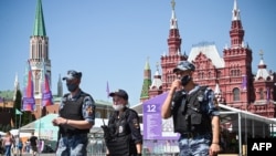 FILE - Russian police and National Guard members wearing face masks walk along Red Square in central Moscow, Russia, June 18, 2021.