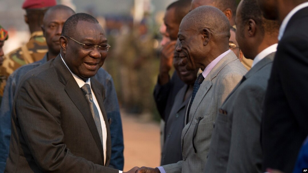 Mantan presiden Republik Afrika Tengah Michel Djotodia bersalaman dengan para pejabat saat ia akan pergi ke Chad (8/1). (AP/Rebecca Blackwell)