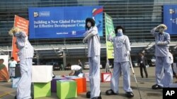 Members from Save the Children and World Vision demonstrate for for effective aid in front of the venue of the fourth High-Level Forum on Aid Effectiveness in Busan, South Korea, November 29, 2011.