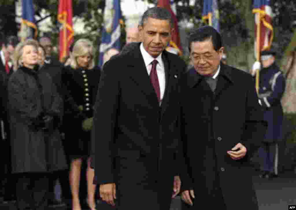 President Barack Obama and China's President Hu Jintao arrive for a state arrival ceremony at the White House in Washington, Wednesday, Jan. 19, 2011. Behind them, from left are, Secretary of State Hillary Rodham Clinton, Jill Biden, and Vice President Jo